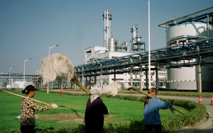 Workers walk past Jilin Fuel, one of the world's largest fuel ethanol plants Picture taken in early September 2003. REUTERS/Nao Nakanishi BY/CP